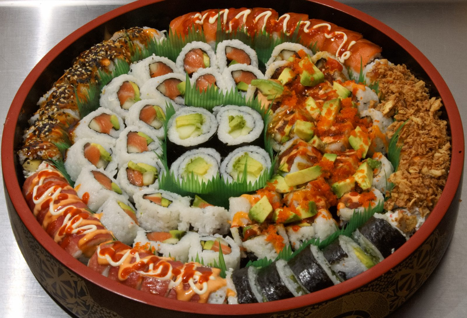 Large round sushi tray with salmon, tuna and dressed rolls